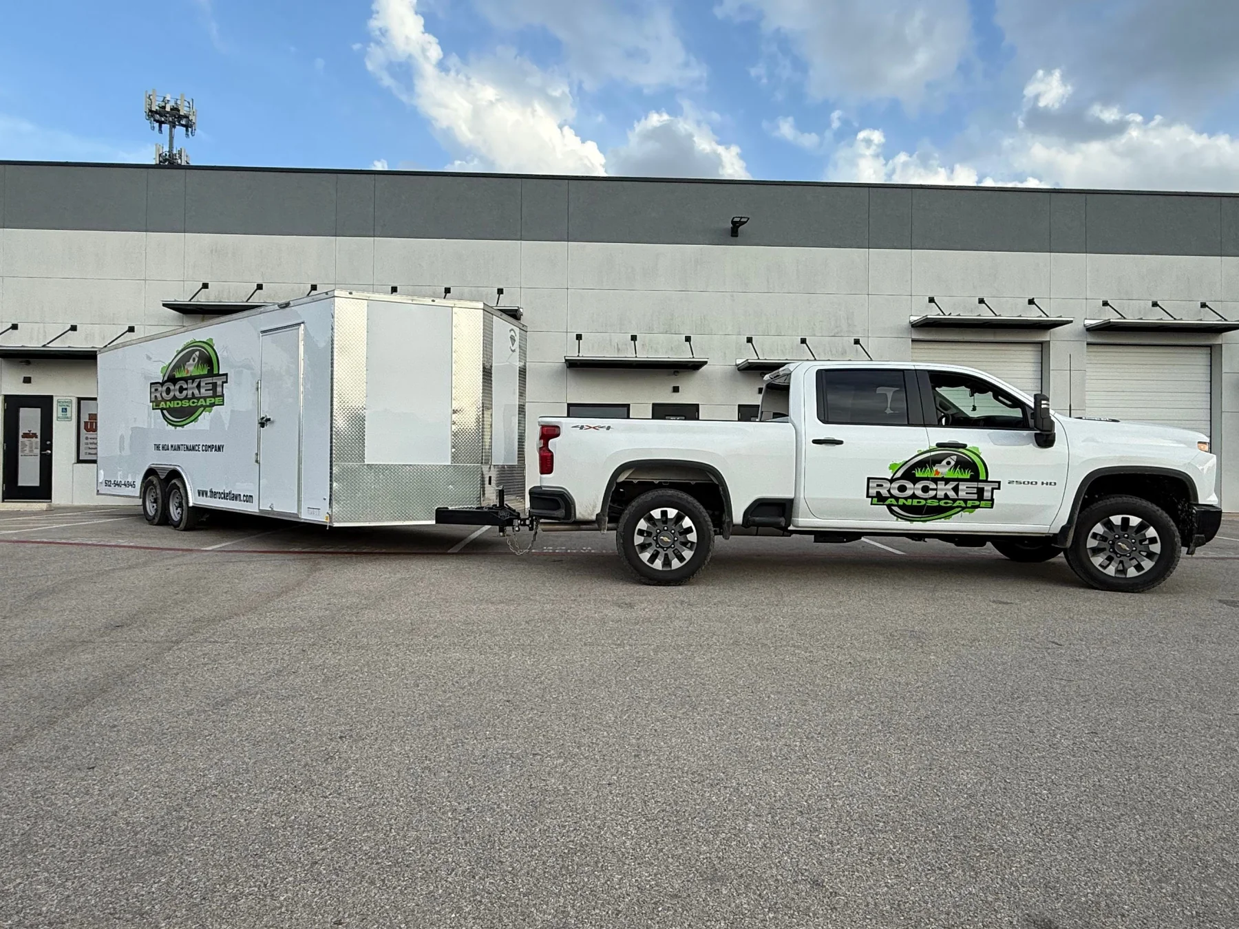 Rocket Landscape branded white truck and enclosed maintenance trailer.