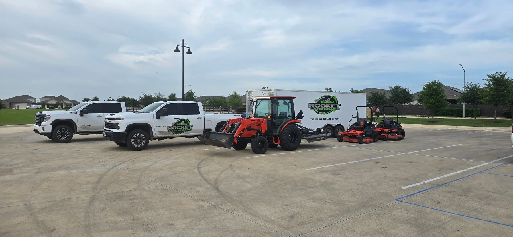 Rocket trucks, branded trailer, tractor and mowers at an HOA community.